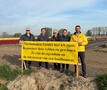 Koen Daniëls en bestuursleden met spandoek bij tulpenveld in Meerdonk
